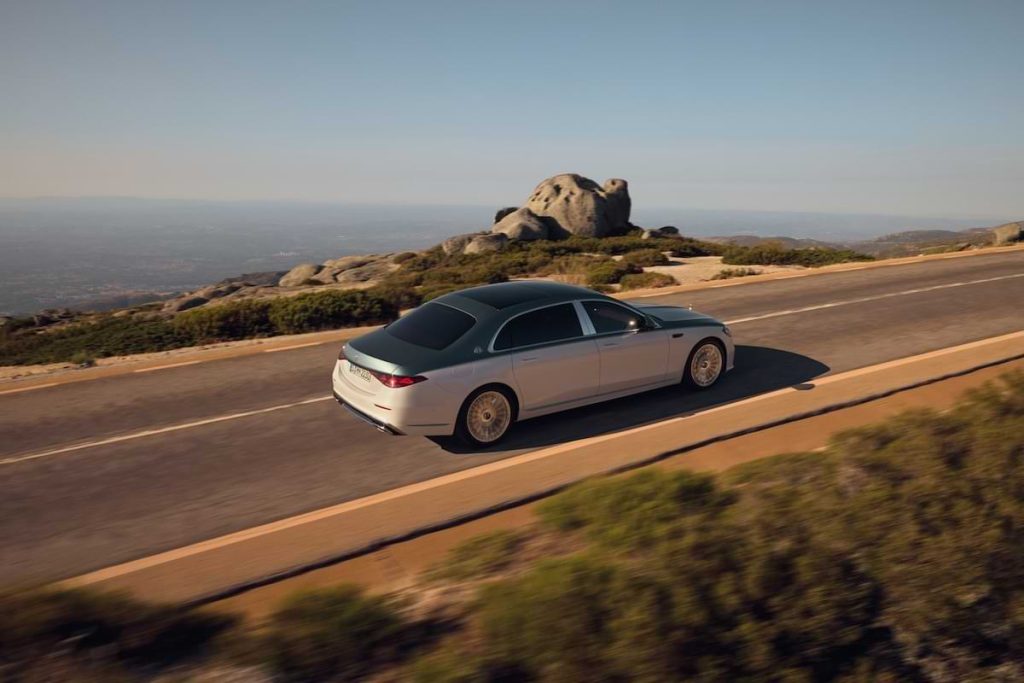 Mercedes-Maybach S-Class driving along a winding mountain road, highlighting its elegant rear design and smooth road presence