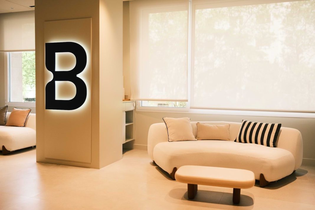 Modern Betandeal office interior with illuminated “B” logo and minimalist lounge area