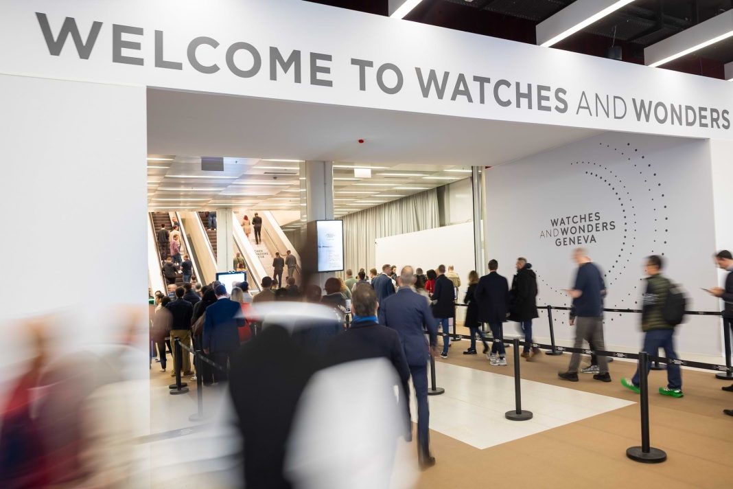 Visitors entering Watches and Wonders Geneva exhibition hall with crowds and event signage at the main entrance