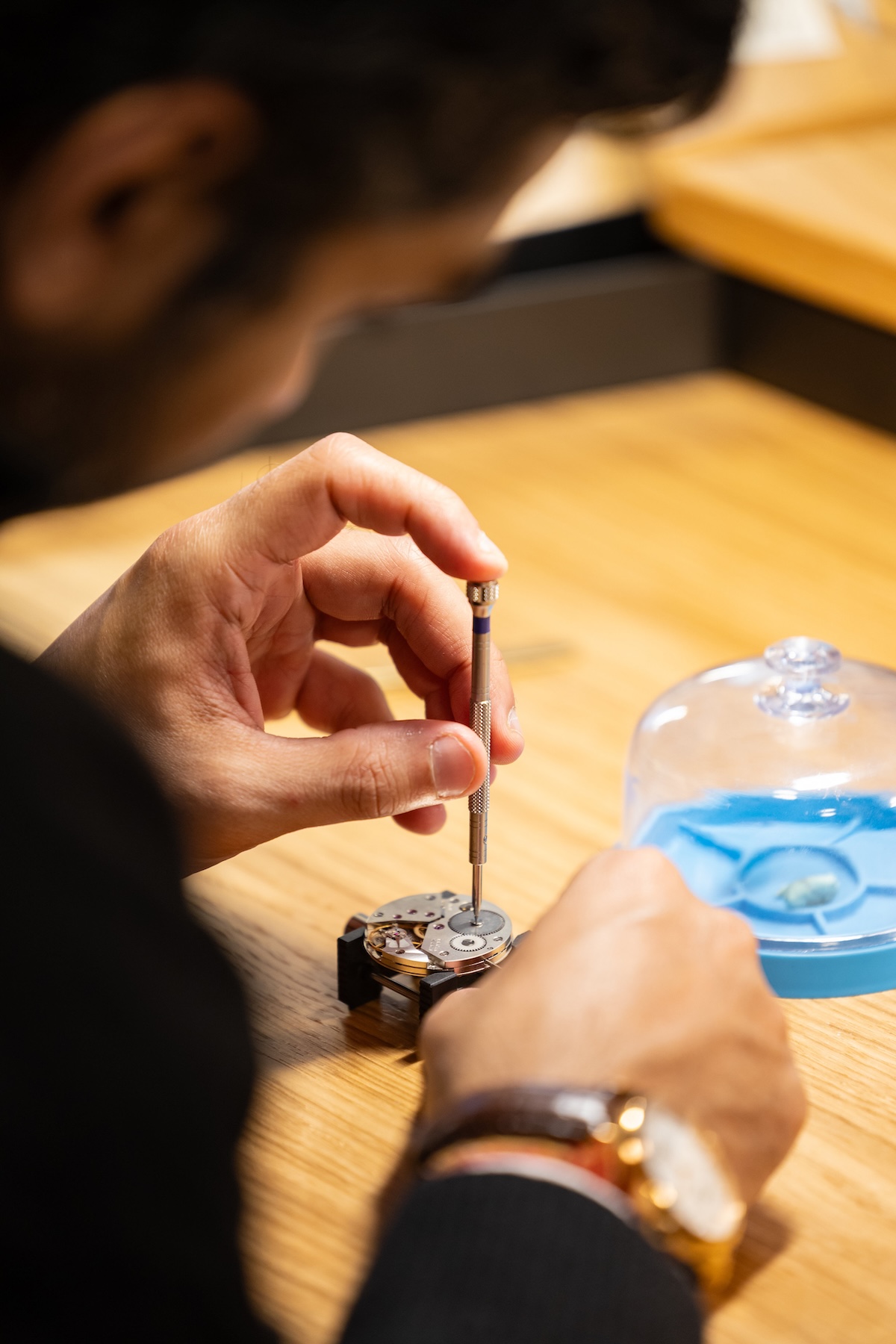 Watchmaker assembling a mechanical watch movement with precision tools at Watches and Wonders Geneva workshop