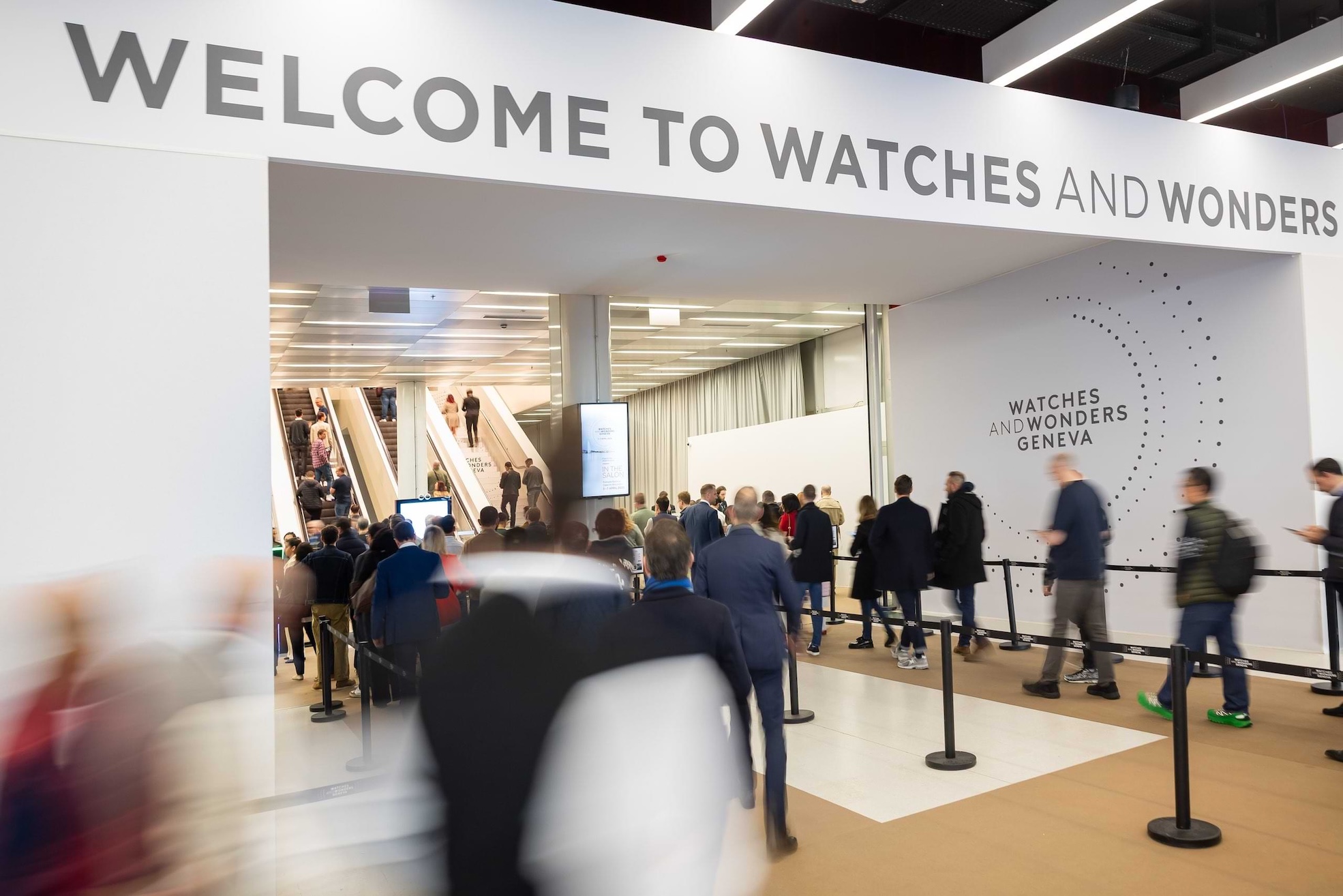Watches and Wonders Geneva 2026: The Pinnacle of High Stakes Living Visitors entering Watches and Wonders Geneva exhibition hall with crowds and event signage at the main entrance