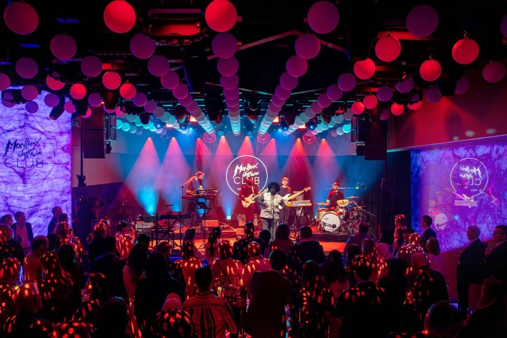 Live music performance at Montreux Jazz Club x Watches and Wonders Geneva with band on stage and audience in vibrant nightclub setting